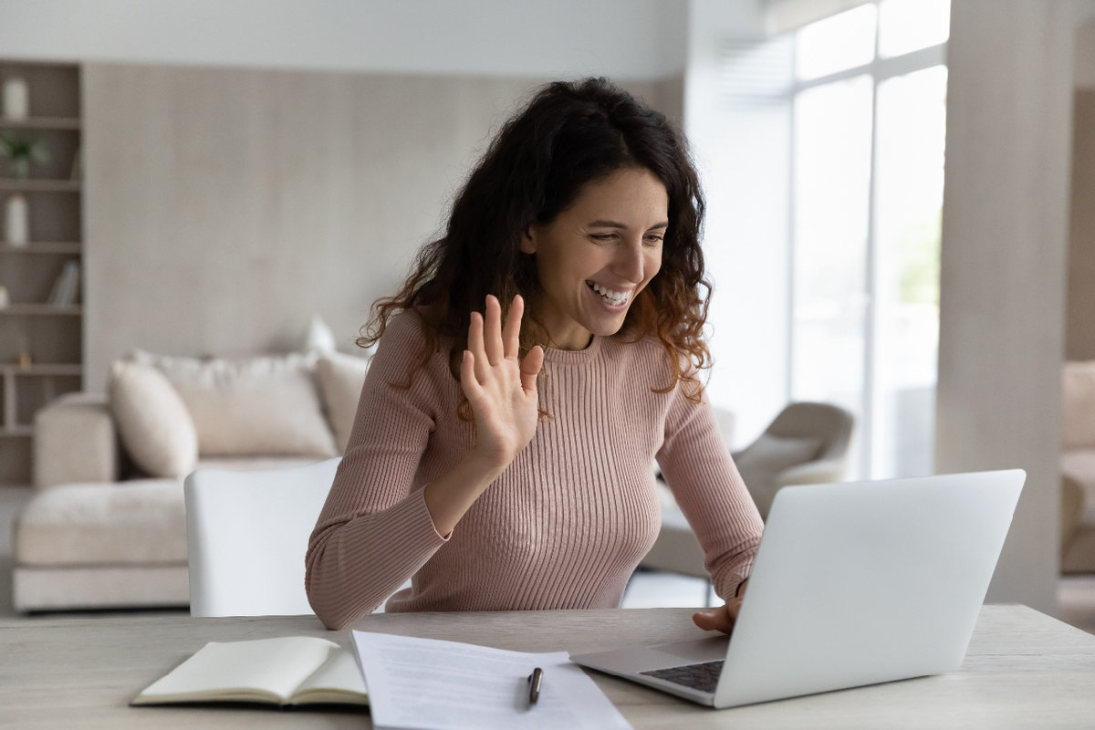 woman waving to screen in a zoom meeting representing booking your introduction call with Sara for your plan